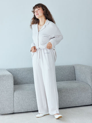 Woman wearing Gelato Pique Snow Lounge Pants in heather gray, standing in a living room setting.