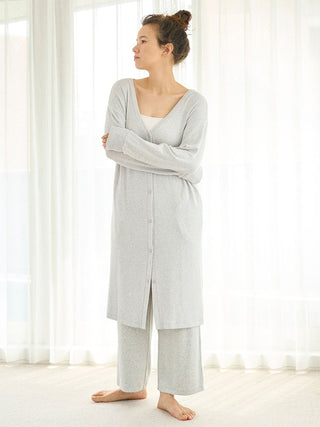 Woman wearing Snow Long Cardigan and matching lounge pants, showcasing a cozy, relaxed fit and deep V-neckline in a light, airy room.