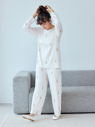 Woman wearing Ice Cream Pattern Long Sleeve Pajama Shirt and pants, standing in a cozy room.