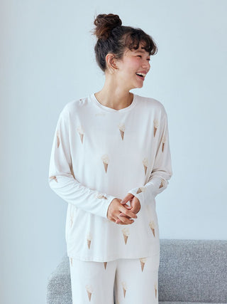 Woman wearing Gelato Pique ice cream pattern long sleeve pajama shirt, featuring a whimsical all-over ice cream cone design.