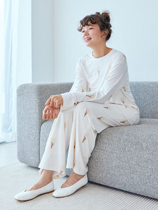 Woman wearing an ice cream pattern long sleeve pajama shirt by Gelato Pique while sitting on a sofa.