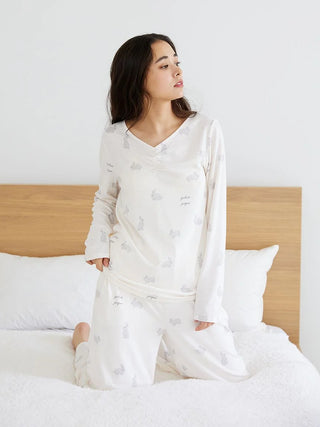 Woman wearing soft long sleeve sleep shirt with rabbit design in cozy bedroom.