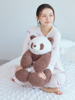 Woman in pink panda-pattern long sleeve T-shirt by Gelato Pique USA hugging a plush panda, showcasing premium loungewear and sleepwear.