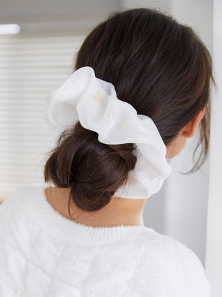 Woman wearing a white bubble scrunchie in a stylish bun with soft fleece texture, adding charm and elegance to her hairstyle.