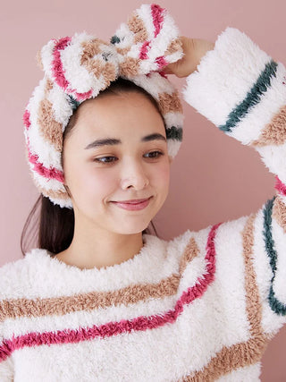 Woman wearing Gelato Plush Lounge Headband with oversized bow, featuring festive stripes, showcasing cozy and playful loungewear style.