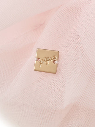 Close-up of a pink tulle fabric with gold Gelato Pique tag, showcasing elegance and luxury of the Tulle Hair Scrunchie.