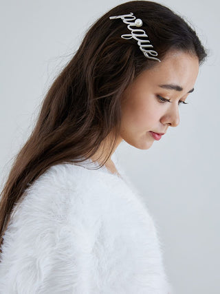 Woman with Metal Logo Barrette featuring script 'Pique' design and pearl accent in her hair, wearing a white shirt.