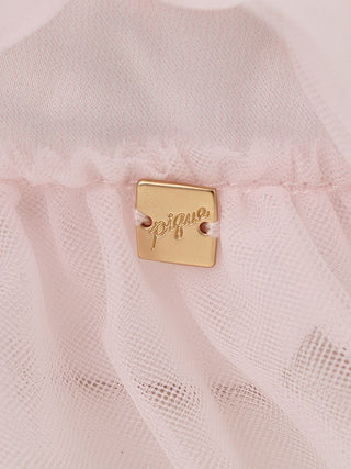 Close-up of pink tulle pouch with a gold-plated charm detail, showcasing the delicate fabric and elegant design.