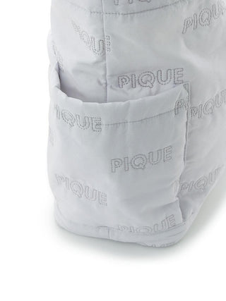 Close-up of PIQUE Quilting Totebag with embossed logo pattern and pocket detail.