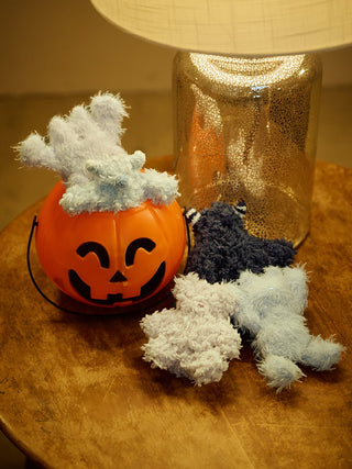 Fluffy Pique Monster Key Charms on a table with a Halloween pumpkin decoration