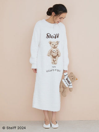 Woman in cozy Steiff x Gelato Pique dress holding Steiff Teddy Bear Jimmy, showcasing a blend of tradition and modern style.