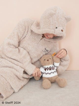 Person in cozy bear costume holding Steiff Teddy Bear Jimmy in Gelato Pique collaboration, showcasing soft plush texture.