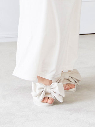 Luxury Velvet Bow Slip-On Shoes with oversized bows on a white carpet, showcasing elegance and plush comfort.