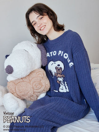 Woman wearing a vintage Peanuts Snoopy and Bear jacquard lounge dress, sitting with a plush Snoopy toy.