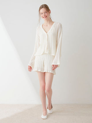 Woman wearing white crochet shorts and top set by Gelato Pique, featuring fine vertical ribbing for an elegant and comfortable fit.