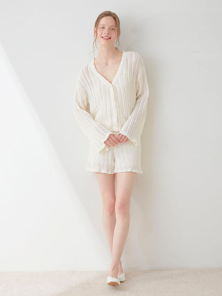 Woman wearing elegant white crochet shorts and top set by Gelato Pique, showcasing detailed ribbing and stylish fit.