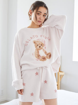 Woman wearing Gelato Pique star jacquard lounge shorts and teddy bear sweatshirt, showcasing cozy and playful loungewear.