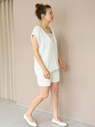 Woman wearing Aran Knit Shorts and matching top, showcasing cable-knit pattern and comfortable fit in a relaxed indoor setting.