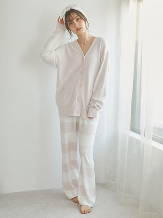 Woman in a soft pastel cardigan and Smoothie 2-Border Pants, featuring relaxed fit and chic stripe design.