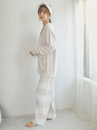 Model showcasing Smoothie 2-Border Pants in pastel colors paired with a cozy sweater, standing by a window.