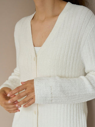 Model wearing a long ribbed knit button-up cardigan in soft white fabric, showcasing a cozy, elegant fit.