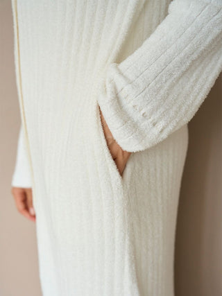 Close-up of ivory long ribbed knit button-up cardigan with pocket detail, showcasing soft texture and elegant style.