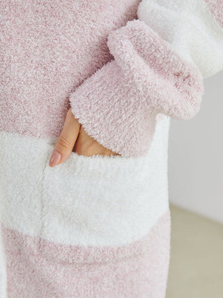 Close-up of fuzzy pink and white striped cardigan sleeve and pocket, showcasing plush texture and cozy elegance.