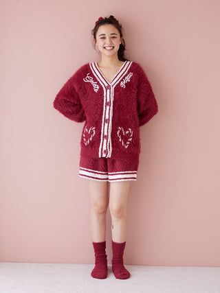 Woman wearing a red feather-textured button-up cardigan with festive charm, perfect for warmth and elegance during winter gatherings.