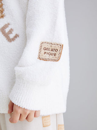 Close-up of Powder Biscuit Jacquard Pullover Sweater in creamy white with biscuit design and Gelato Pique patch on sleeve.