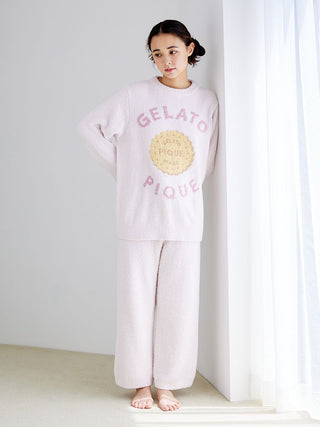 Woman wearing Powder Biscuit Jacquard Pullover Sweater from Gelato Pique, standing barefoot by a window in soft natural light.