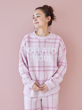 Woman wearing Gelato Pique checkered pajama set in pastel tones, featuring a relaxed fit, against a light pink background.