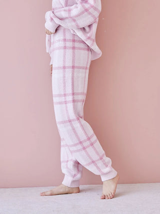 Woman wearing a pastel checkered pajama set made of soft fabric, featuring a relaxed fit and cozy design, perfect for lounging.