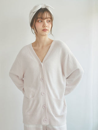 Woman wearing a pink Smoothie Button-Up Cardigan, showcasing its cozy and luxurious soft fabric with a classic button-up style.