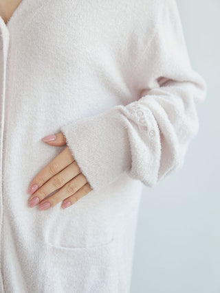 Close-up of a pale pink 2025 Smoothie Cardigan featuring a V-neck, front pockets, and embroidered cuff detail.