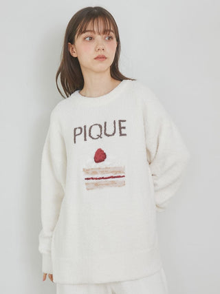 Woman wearing Cake Jacquard Pullover Sweater with PIQUE lettering, featuring a cake motif, soft knit fabric for cozy loungewear.