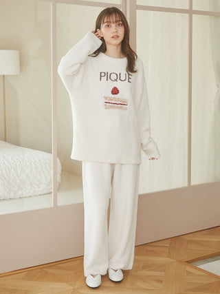 Woman wearing Cake Jacquard Pullover Sweater with cake motif and 'PIQUE' lettering in a cozy indoor setting.