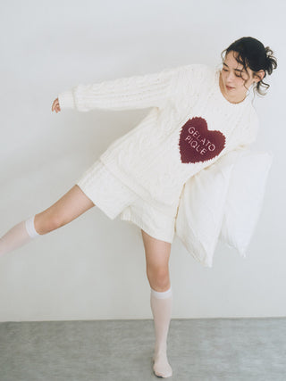 Woman wearing cozy Heart Aran Pullover Sweater with embroidered heart, showcasing Gelato Pique style.