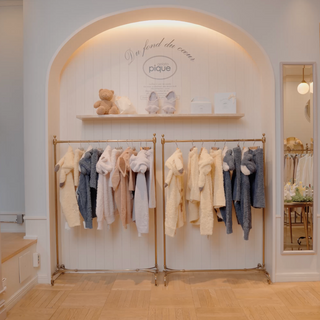 Cozy boutique interior showcasing racks of fluffy pastel sweaters and cute teddy bears on a shelf, creating a warm atmosphere.