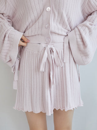 Light pink ribbed shorts with a tie waist and merrow hem detail, paired with matching cardigan.