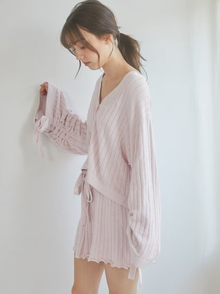 Woman wearing a 2025 ribbed cardigan, showcasing its cozy and elegant design in soft knit fabric perfect for stylish layering.