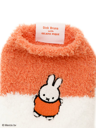 Close-up of Dick Bruna and GELATO PIQUE collaboration orange and white striped socks with Miffy embroidery.