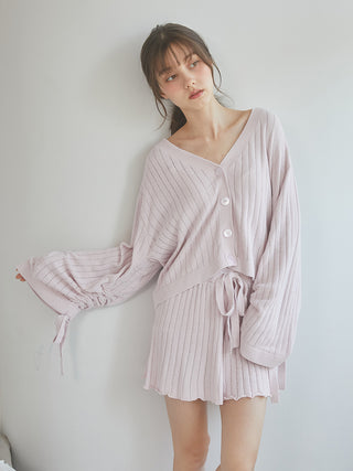 Woman wearing 2025 ribbed shorts and matching cardigan in soft pink, showcasing the feminine and casual outfit style.