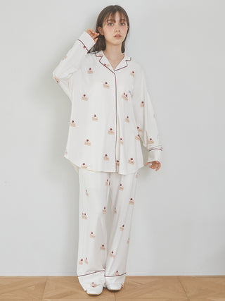 Woman wearing cake motif long pajama pants with strawberry shortcake print, highlighting the silky rayon fabric and piping details.