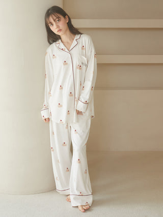 Woman wearing sweet shortcake-print pajama pants, made from silky rayon fabric with strawberry shortcake motifs and piping details.